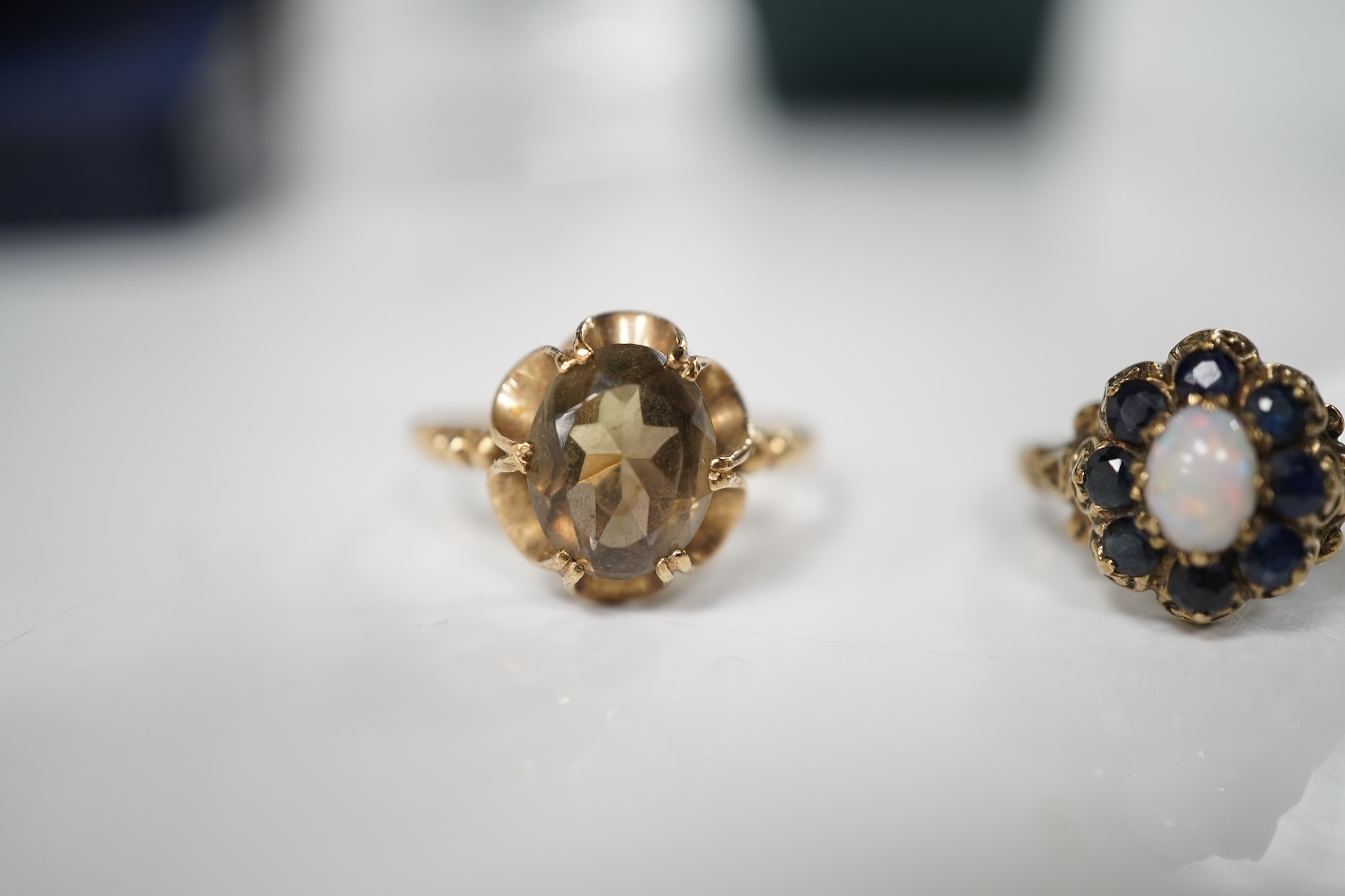 A collection of jewels, comprising: an opal and sapphire cluster ring and a citrine ring in 9ct gold, each with British hallmarks, combined gross weight approximately 4 grams; together with a pair of blue topaz and marca